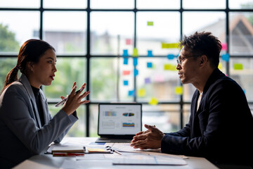 Two people are talking in a meeting room