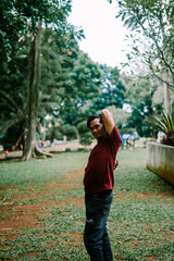 Fototapeta premium Southeast Asian man scratching his back, expressing discomfort from itching
