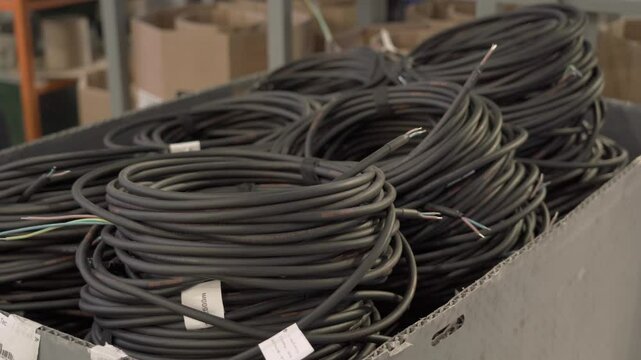 Thick black cables in a factory for the production of lamps for street lighting. Industrial production.