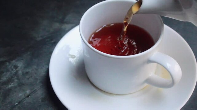 tea in a teapot poured into a cup