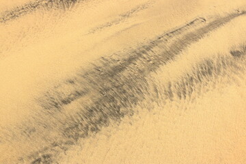 Atlantic ocean beach sand texture at Fuerteventura. Black and yellow sand