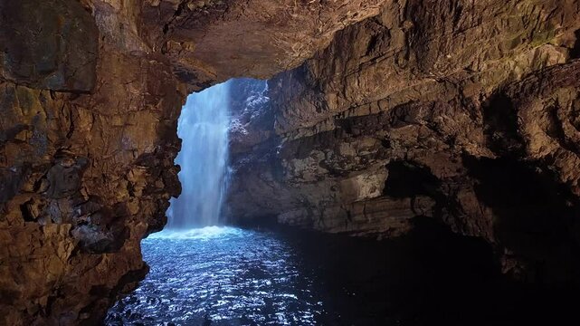Wide shot of the underground waterfall at Smoo Cave, Scotland