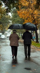 A couple walks under umbrellas on a rainy day, surrounded by autumn foliage.
