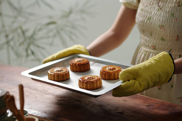 Close-up of woman holding pan with homemade cakes