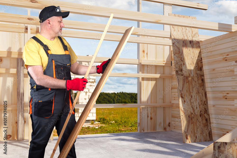 Poster boards in hands of builder. man builds house from wood. construction using frame technology. builder