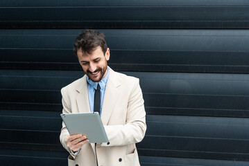 Portrait of young businessman standing outside office building. Successful professional office...