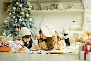 Happy family drawing a picture Together Near Christmas Tree During Christmas Day