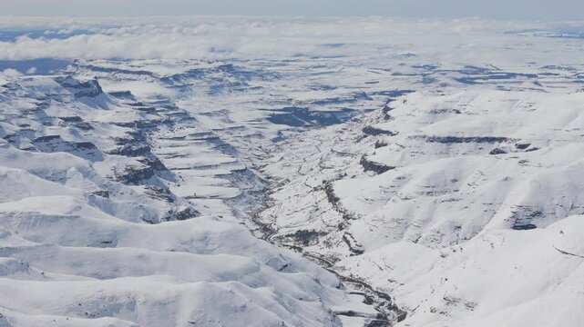 Aerial view of cliffs and mountains of KwaZulu-Natal highlands near Sani Pass covered in snow