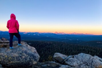 Naklejka premium Woman Hiker Standing on Mountain Peak Overlooking Scenic Landscape