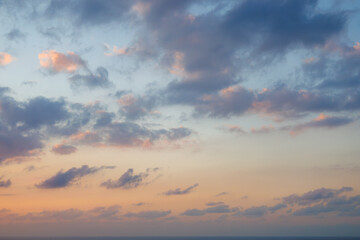 Majestic dusk. Sunset sky twilight in the evening with colorful sunlight. Abstract nature background. Calm orange and blue sky with dark violet, purple and yellow clouds.