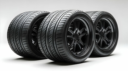 Four black alloy wheels with performance tires arranged in a row.