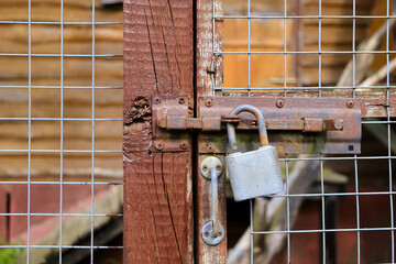 Close-Up Of An Old Wooden Gate Fastened With A Weathered Padlock, Symbolizing Security And...