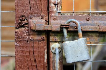 Close-Up Of A Rusty Padlock On An Aged Wooden Gate, Symbolizing Security Concerns And Rustic Charm. Ideal For Concepts Of Protection And Neglect.