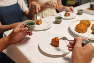 Close-up of family eating moon cakes at table during holiday