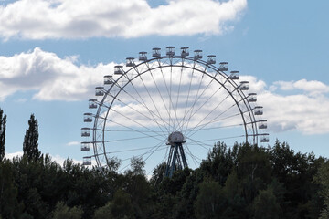 A Beautiful Ferris Wheel Set Against A Vibrant Blue Sky With Fluffy Clouds. This Image Captures The Essence Of Leisure And Adventure In Nature.