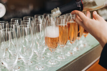 Alcohol setting on catering banquet table, bartender pouring liquor beverages, row line of different colored alcohol drinks on a party, glass of wine, sparkling wine on decorated banquet table event