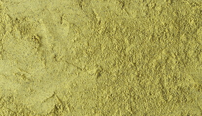 Pumpkin seeds minced, green powder background and texture, top view