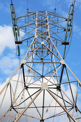 A Metal Electrical Tower With High-Voltage Power Lines Rises Against A Bright Blue Sky. The Image Captures The Essence Of Energy Infrastructure And Industrial Strength.