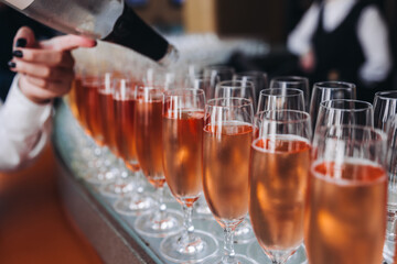 Alcohol setting on catering banquet table, bartender pouring liquor beverages, row line of different colored alcohol drinks on a party, glass of wine, sparkling wine on decorated banquet table event