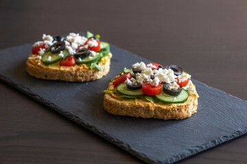 Mediterranean Hummus Toast with Cucumber, Tomato, Olive, and Feta - Close-Up