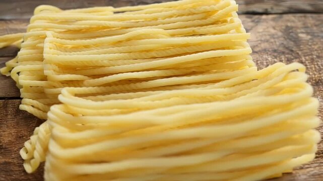 On a rustic wooden tabletop, there are several packs of uncooked whole wheat spaghetti basking in the soft glow of natural light, ready to be transformed into a delicious and healthy meal