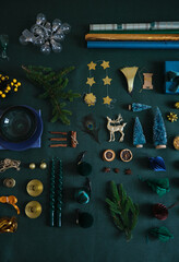 Christmas festive preparation concept flat lay on the green linen fabric. Xmas objects for table and tree decoration