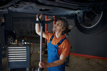 Professional automotive engineer working at car repair station