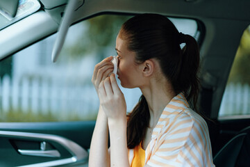 woman applying makeup in car, personal grooming, beauty routine, self care, urban setting, casual attire, bright colors, soft natural light, modern lifestyle, reflective moment, serene atmosphere