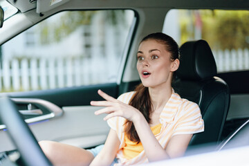 Car interior conversation, young woman, casual outfit, expressive gesture, seated in vehicle, bright natural light A lively moment captured inside a modern car