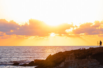 The Sea and coast next to the shipwreck EDRO III with a silhoute of a photographer with tripod and sunset