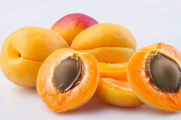 Apricots and fruit in a grey. Healthy food vegetarian concept. Apricots and oranges on a grey. Apricots and oranges on a white lifestyle with white flowers.