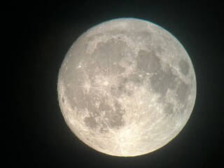 Obraz premium view of the full moon through a telescope on the eve of the supermoon and the rising of the blue moon in the sky