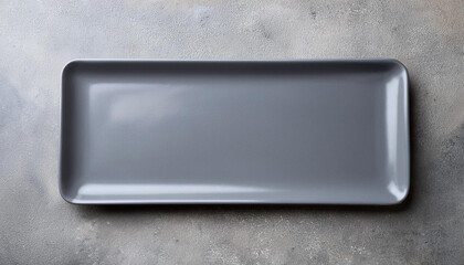 Gray empty rectangular plate over concrete background.