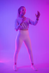 Young woman explores virtual reality in dynamic neon lighting