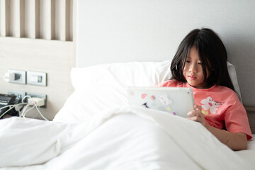 kid watching tablet on the bed, child addicted cartoon