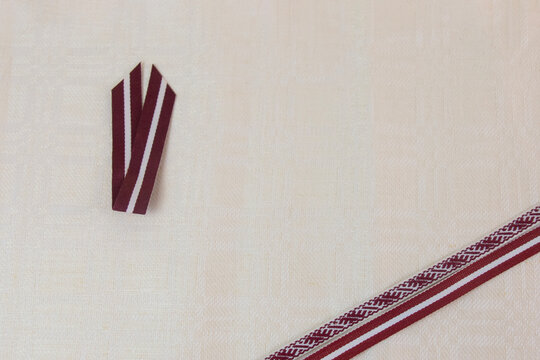 red and white ribbon, symbol of independence day, on linen fabric, symbol of the day of the proclamation of the republic, independence of the republic with space for text