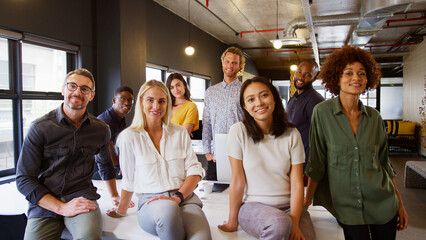 Portrait Of Smiling Multi-Cultural Business Team In Modern Open Plan Office Together
