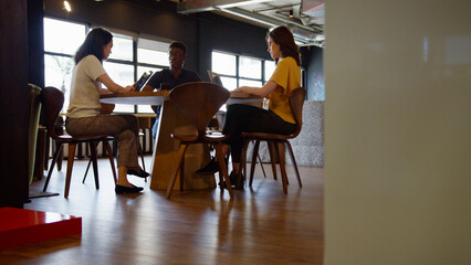 Informal Meeting Area In Modern Office With Businesspeople Meeting And Working At Tables