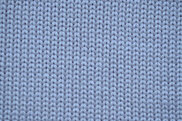Macro texture of wool blue crocheted sweater as background, close-up of pastel blue crocheted front, blue crocheted back, texture of wool wool, blue crocheted front