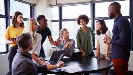 Multi-Cultural Business Team Meeting And Collaborating Around Table In Modern Office Together