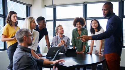 Multi-Cultural Business Team Meeting And Collaborating Around Table In Modern Office Together