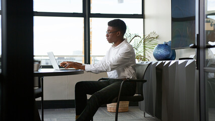 Young Businessman Working On Laptop At Desk In His Own Office