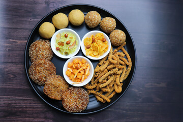 Indian festival food. Diwali Special sweet and salty snacks include Chakli, coconut laddu, besan ladu, poha and sabudana chivda, corn or maka mixture, Anarasa. Diwali Faral from Maharashtra, India.