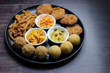 Indian festival food. Diwali Special sweet and salty snacks include Chakli, coconut laddu, besan ladu, poha and sabudana chivda, corn or maka mixture, Anarasa. Diwali Faral from Maharashtra, India.
