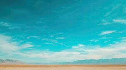 A bright blue sky stretching endlessly over a tranquil desert landscape.