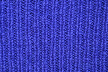 Fototapeta premium Macro texture of purple wool crochet sweater as background, close-up of purple crochet front surface, texture of woolen wool, crochet front surface