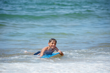 A youngster plays on boogie board at the seaside wait for wave