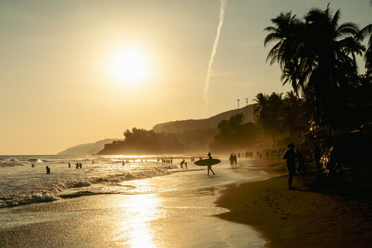 Beach scene at sunset with silhouetted figures in El Salvador