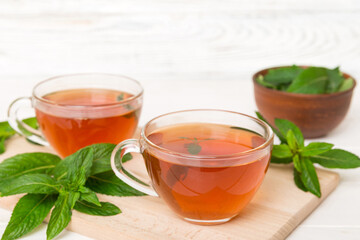 Cup of mint tea on table background. Green tea with fresh mint top view with copy space