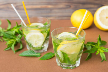 Fototapeta premium Mojito summer refreshing cocktail with ice and mint. mojito cocktail with lime, lemon and mint in a tall glass with a stick